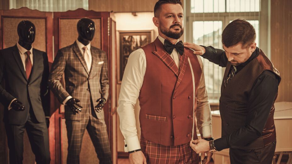 Close-up of a man wearing a perfectly tailored suit, showcasing the fit around the shoulders, waist, and legs.