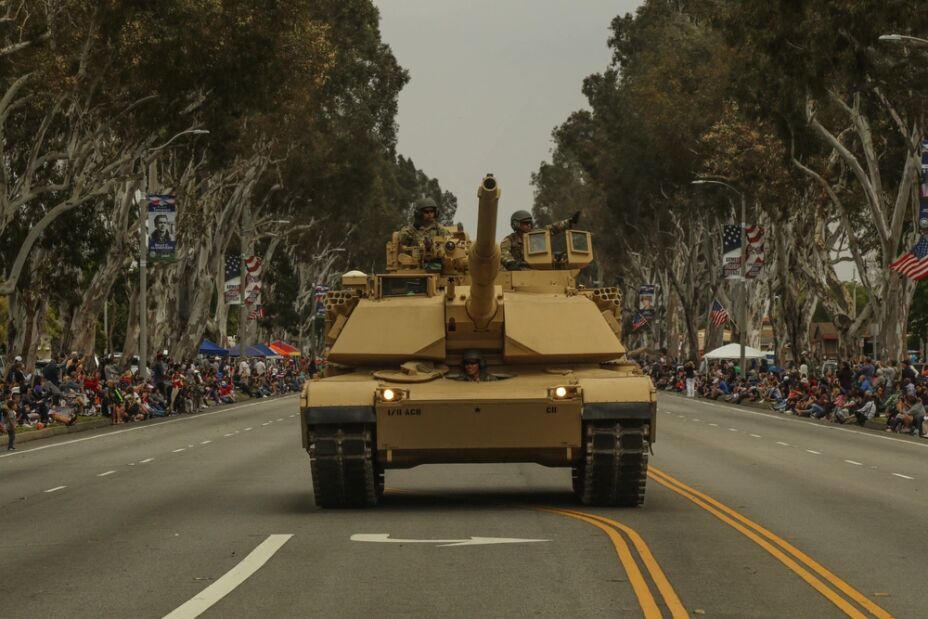 M1 Abrams tank heads the Torrance Armed Forces Day parade as spectators wave flags, May 2025.”