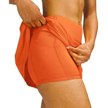 MEIVSO Women's Pleated Workout Tennis Skirts with Pockets Activewear Sports Skort Built-in Shorts (Orange, X-Small)
