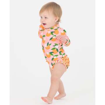 RuffleButts Baby Girls UPF 50+ Sun Protection Novelty Print Long Sleeve One Piece Rash Guard Swimsuit with Zipper - Orange You The Sweetest, 12-18m