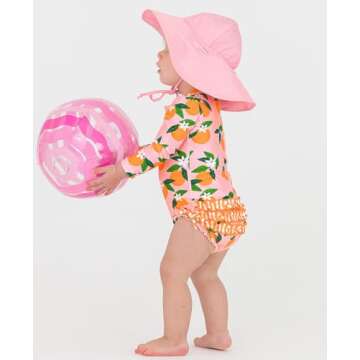 RuffleButts Baby Girls UPF 50+ Sun Protection Novelty Print Long Sleeve One Piece Rash Guard Swimsuit with Zipper - Orange You The Sweetest, 12-18m