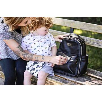 Itzy Ritzy Mini Diaper Bag Backpack – Chic Mini Diaper Bag with Changing Pad, 8 Total Pockets (4 Internal and 4 External), Grab-Top Handle and Rubber Feet (Black)